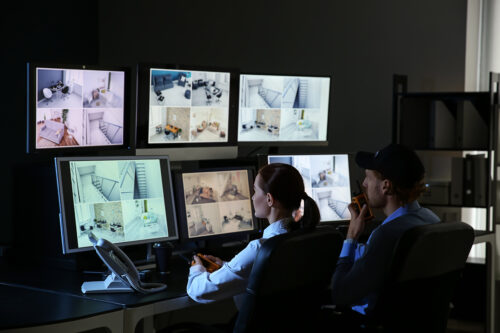 Security guards monitoring modern CCTV cameras in surveillance room