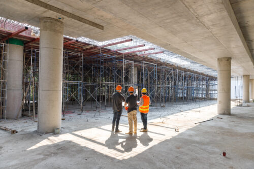 Construction concept of Engineer and Architect working at Construction Site with blue print