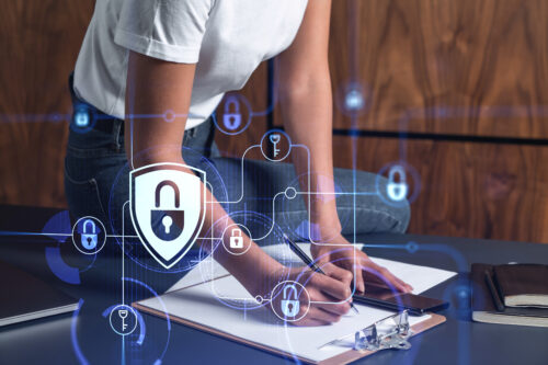 A woman dev member is taking notes of clients needs to protect cyber security from hacker attacks and save clients confidential data. Using smart phone. Padlock Hologram icons. Casual wear