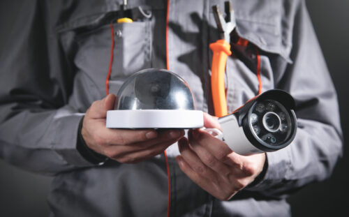 Man holding surveillance security camera.